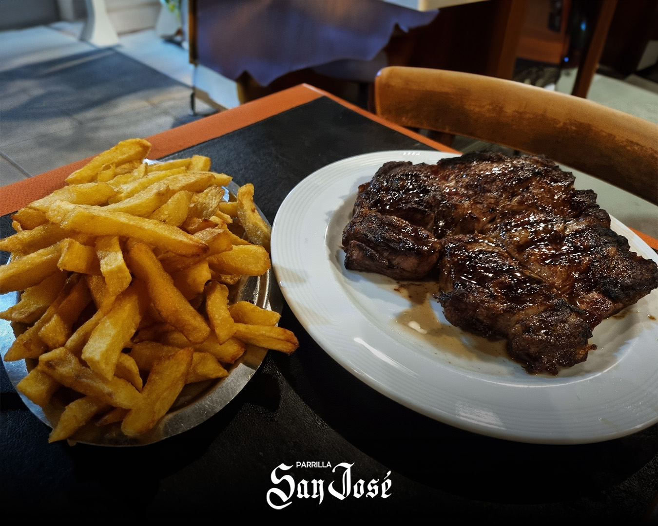 Bife de chorizo con papas fritas, recién salido de la parrilla